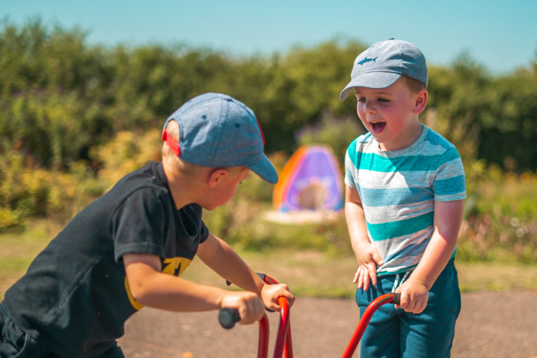 Boys in caps playing on kick scooters