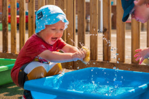 Child playing with sponge in water