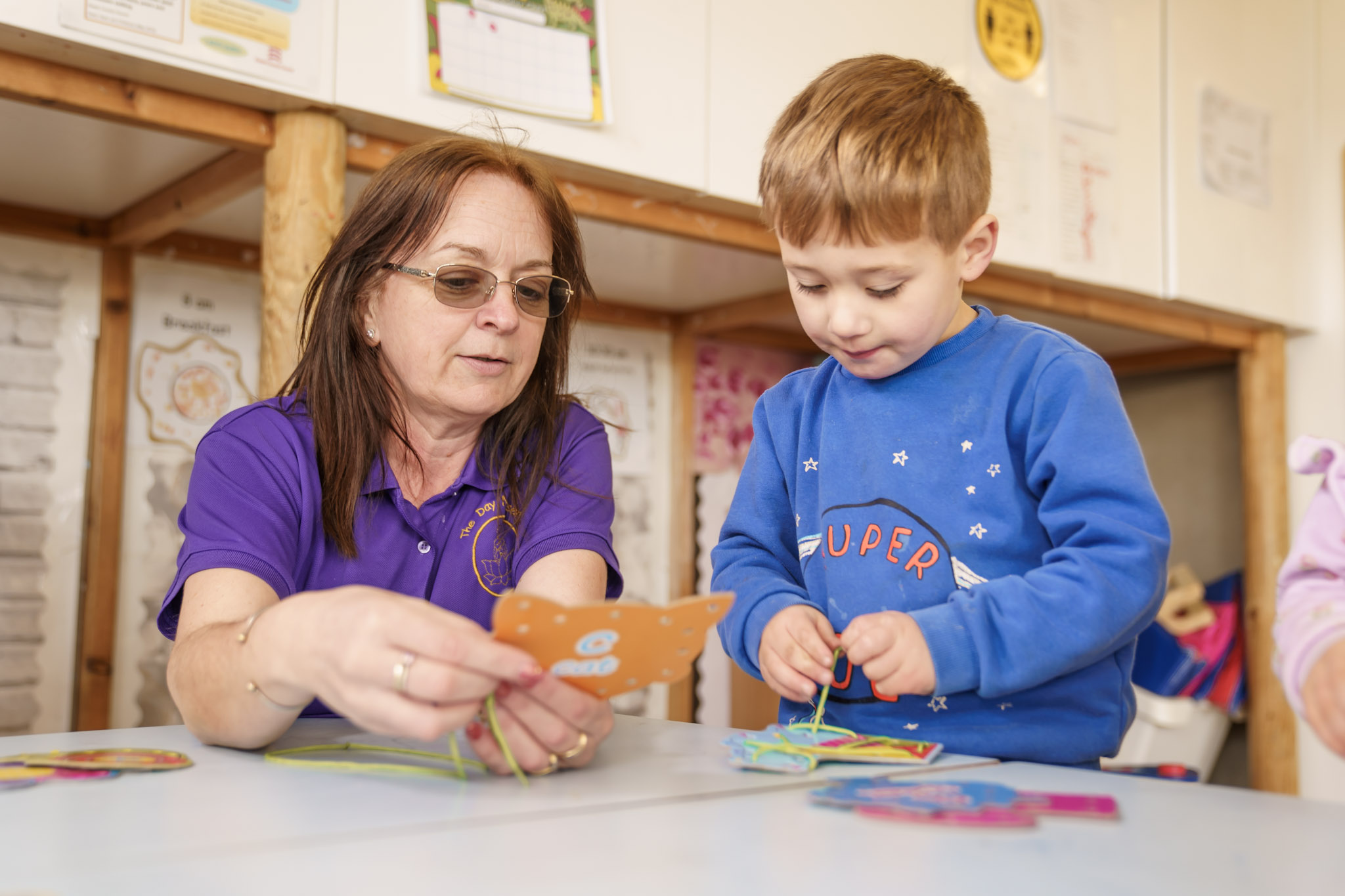 Boy learning with nursery staff