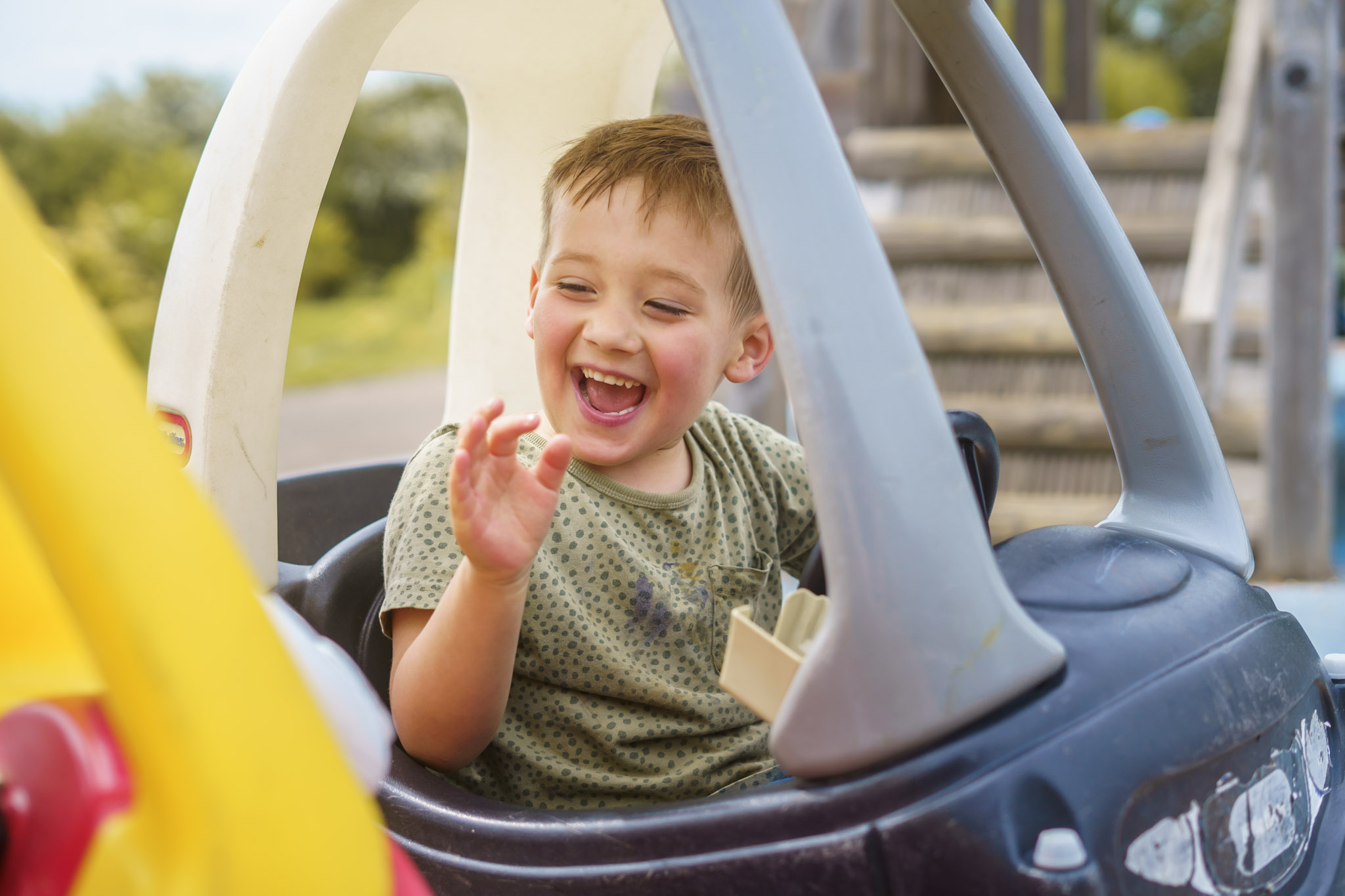Child laughing in toy car